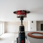 Вырезка отверстия коронкой в натяжном потолке с термокольцом рядом